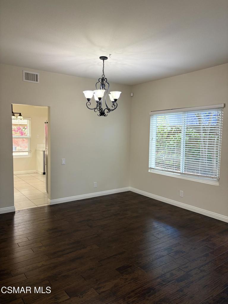 12015 River Grove Court Moorpark, CA 93021 - Photo 11 of 33 an empty room with wooden floor chandelier and windows