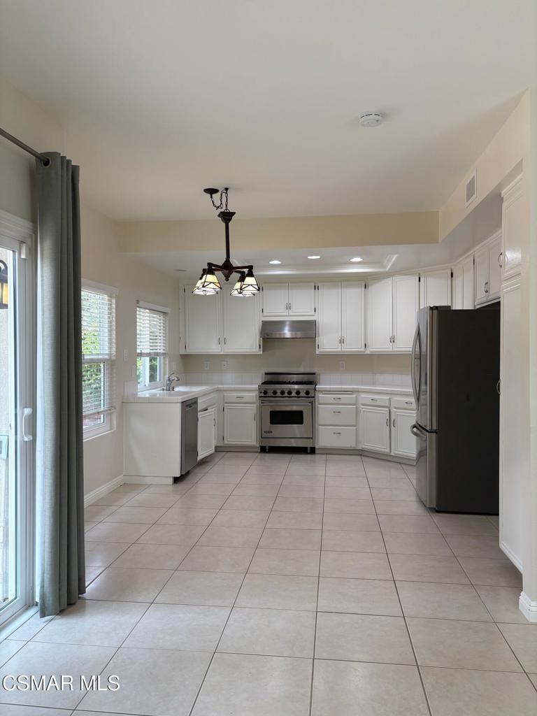 12015 River Grove Court Moorpark, CA 93021 - Photo 8 of 33 a large kitchen with stainless steel appliances granite countertop a refrigerator and a stove top oven
