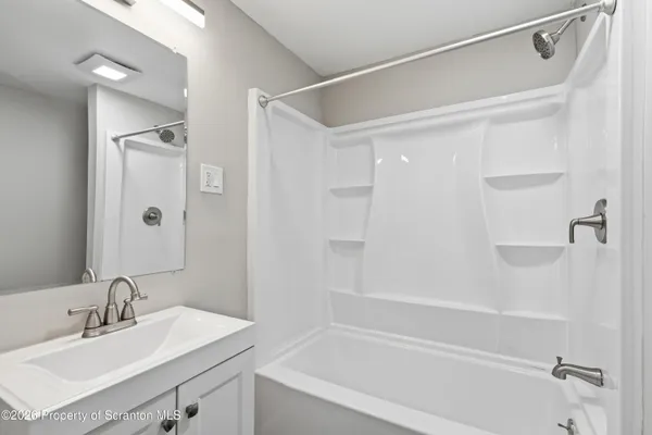 a bathroom with a shower sink vanity and mirror