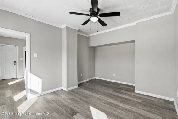 a view of empty room with wooden floor