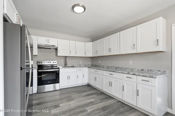 a kitchen with granite countertop a sink stainless steel appliances and cabinets