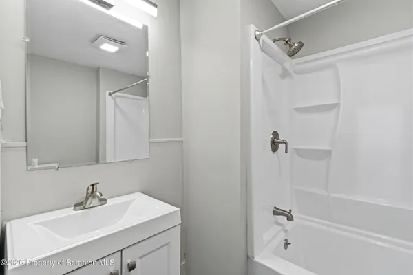 a bathroom with a sink mirror and a bathtub