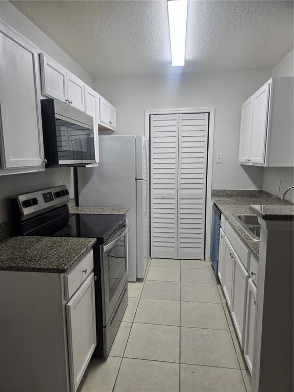4316 South Kirkman Road, Unit 1608 Orlando, FL 32811 - Photo 5 of 16 a kitchen with a stove sink and cabinets