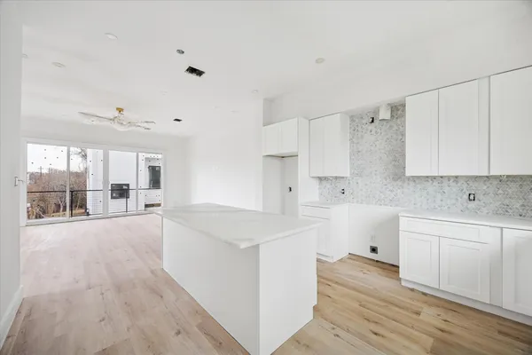 a view of a kitchen with wooden floor and electronic appliances
