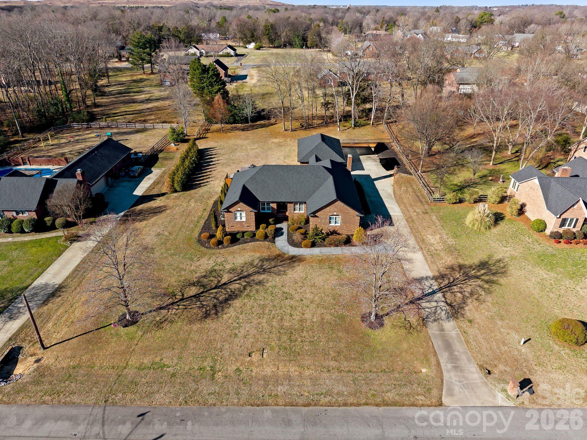 an aerial view of a house with a yard and seating space