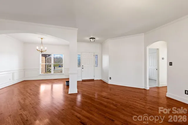 a view of empty room with wooden floor and window