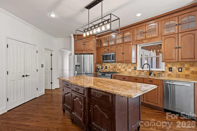 a kitchen with stainless steel appliances granite countertop a sink and a refrigerator