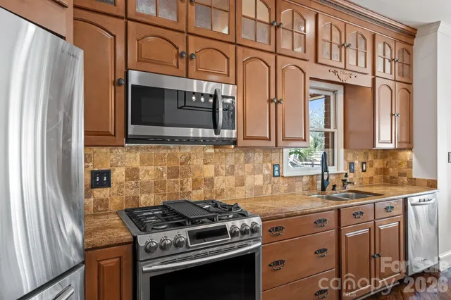 a kitchen with stainless steel appliances granite countertop a stove microwave and cabinets