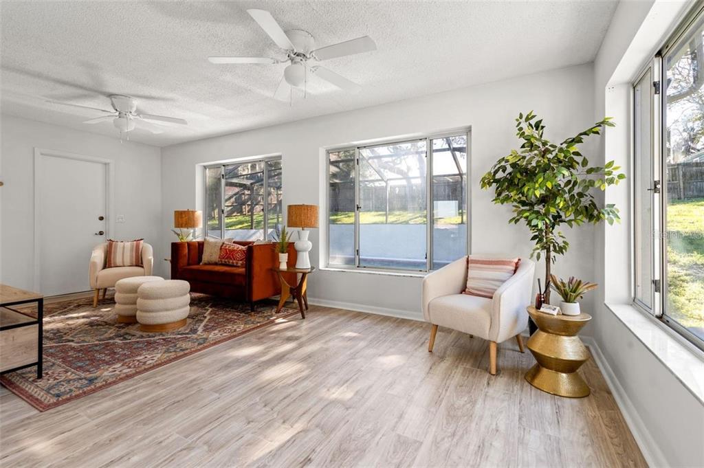 7370 Holiday Drive Spring Hill, FL 34606 - Photo 3 of 9 a living room with furniture and a large window with wooden floor