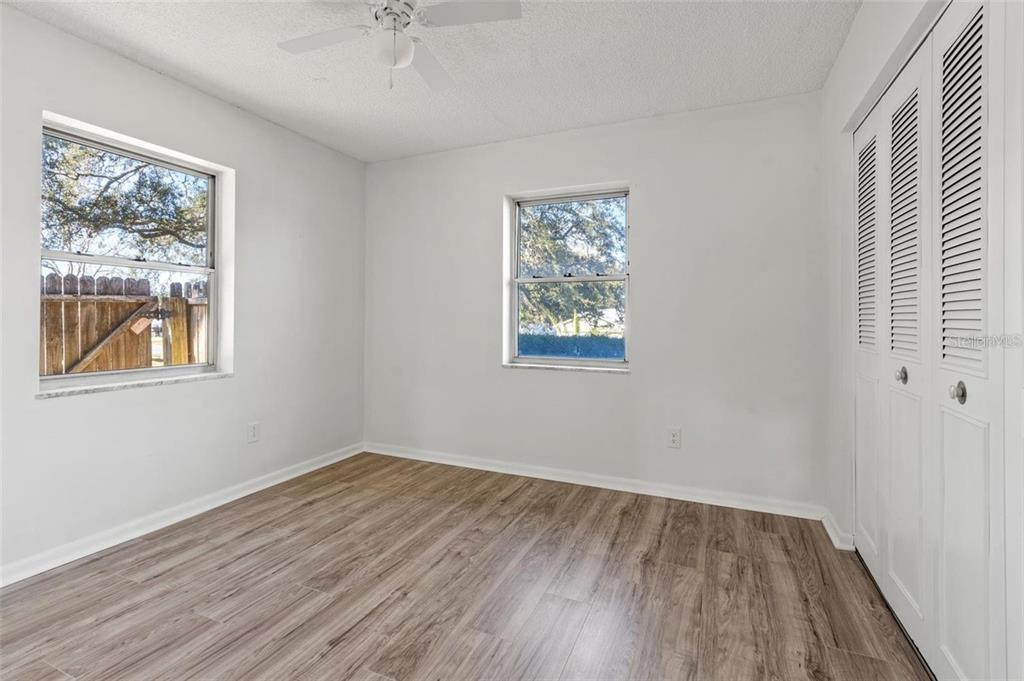 7370 Holiday Drive Spring Hill, FL 34606 - Photo 6 of 9 a view of an empty room with wooden floor and a window