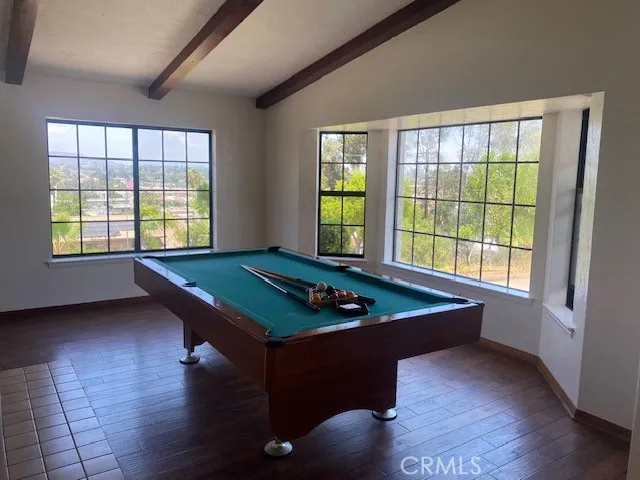 a room with pool table and windows