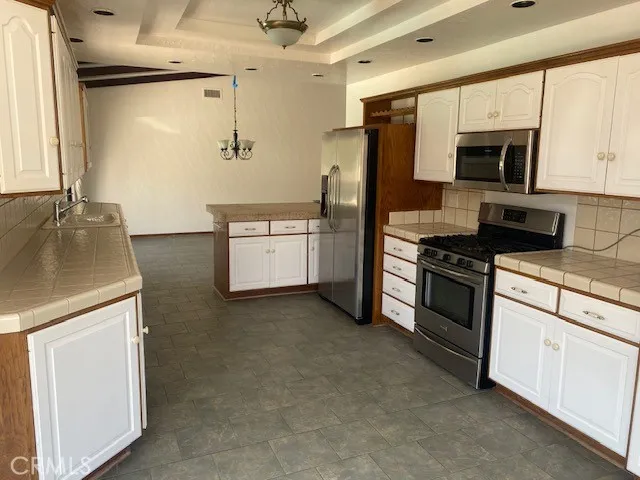 a kitchen with stainless steel appliances a stove microwave and refrigerator