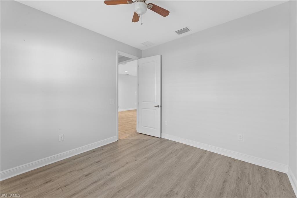 3711 Canopy Circle Naples, FL 34120 - Photo 12 of 28 an empty room with wooden floor and windows