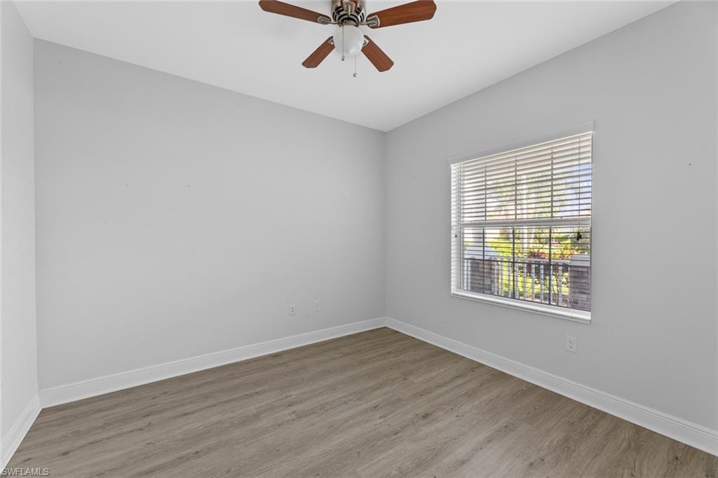 3711 Canopy Circle Naples, FL 34120 - Photo 13 of 28 an empty room with wooden floor and windows