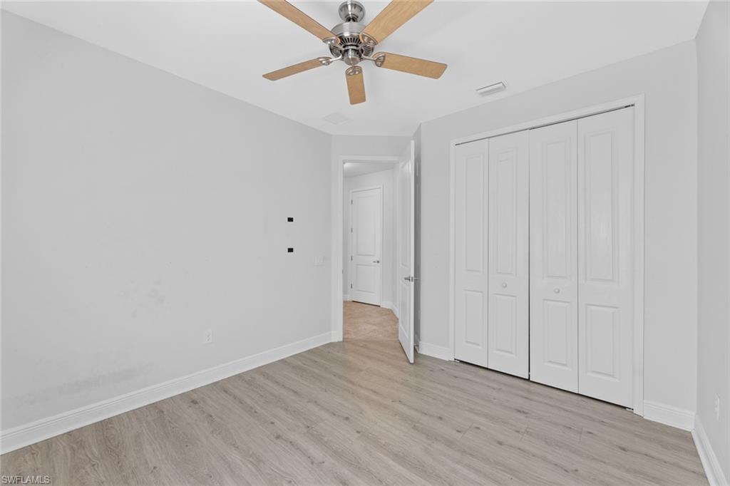 3711 Canopy Circle Naples, FL 34120 - Photo 15 of 28 a view of an empty room with window a ceiling fan and wooden floor