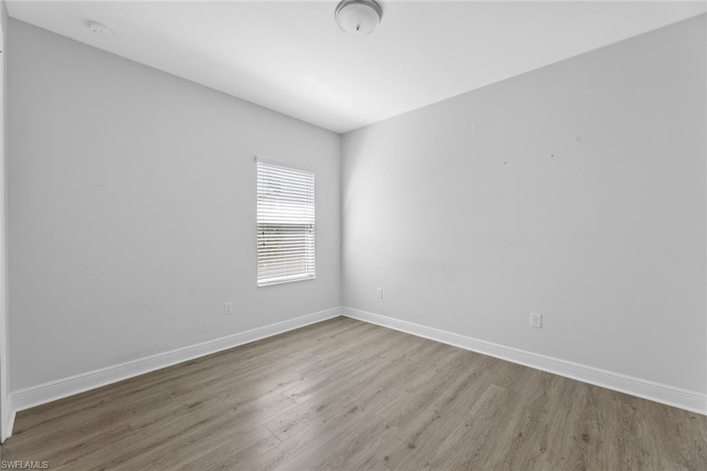 3711 Canopy Circle Naples, FL 34120 - Photo 16 of 28 a view of an empty room with wooden floor and a window