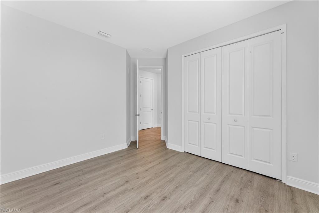 3711 Canopy Circle Naples, FL 34120 - Photo 17 of 28 a view of an empty room with wooden floor
