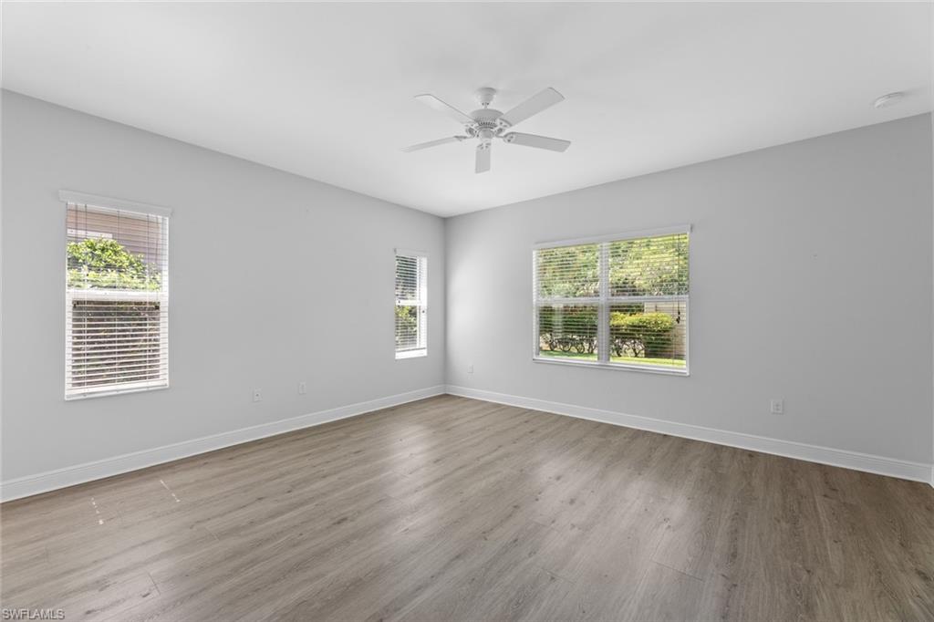 3711 Canopy Circle Naples, FL 34120 - Photo 18 of 28 a view of an empty room with a window and wooden floor