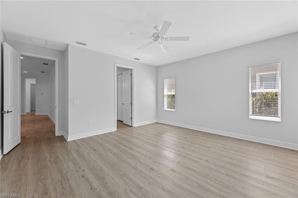 3711 Canopy Circle Naples, FL 34120 - Photo 19 of 28 a view of an empty room with wooden floor and a window