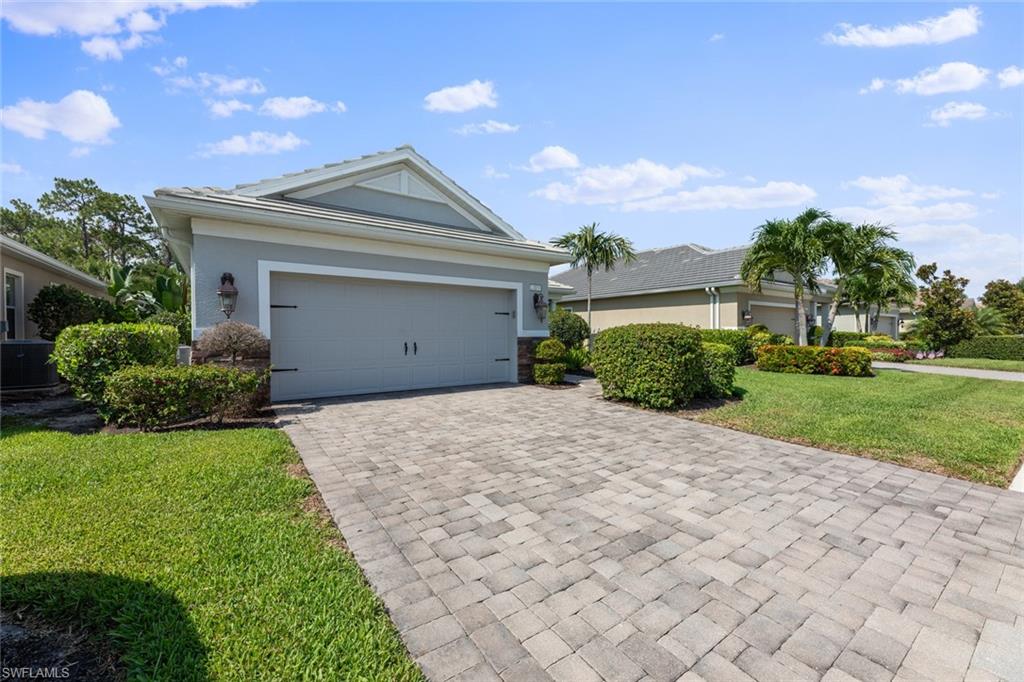3711 Canopy Circle Naples, FL 34120 - Photo 2 of 28 a front view of a house with a yard and garage