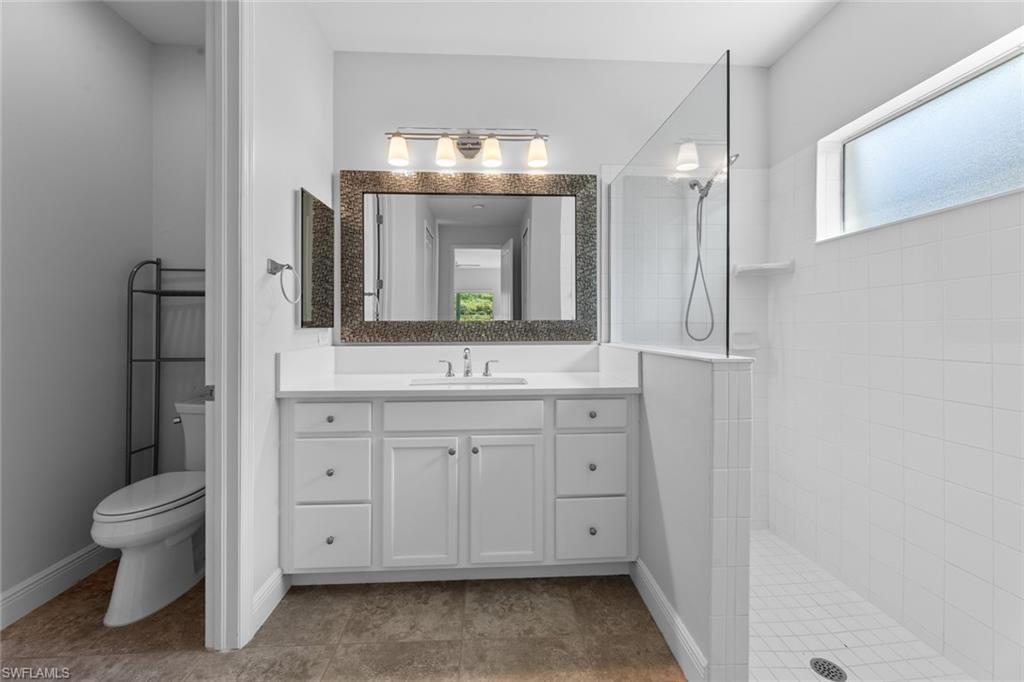 3711 Canopy Circle Naples, FL 34120 - Photo 21 of 28 a spacious bathroom with a double vanity sink and a mirror