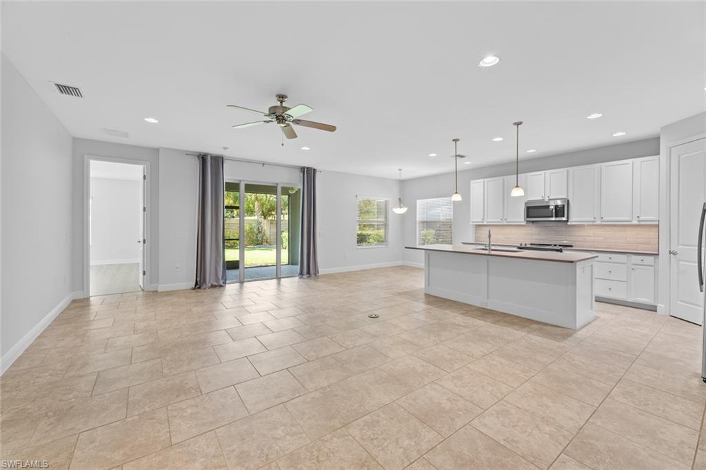 3711 Canopy Circle Naples, FL 34120 - Photo 3 of 28 a view of kitchen with kitchen island stainless steel appliances refrigerator sink and cabinets