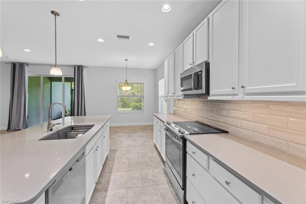 3711 Canopy Circle Naples, FL 34120 - Photo 8 of 28 a kitchen with stainless steel appliances granite countertop a sink and a stove