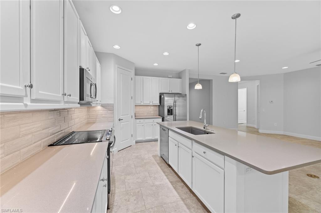 3711 Canopy Circle Naples, FL 34120 - Photo 9 of 28 a large white kitchen with lots of counter space sink and appliances