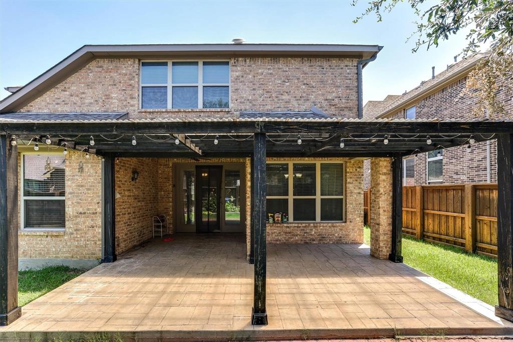 419 Rio Grande Drive Irving, TX 75039 - Photo 29 of 29 Brick exterior with a covered patio featuring a corrugated metal roof and string lighting