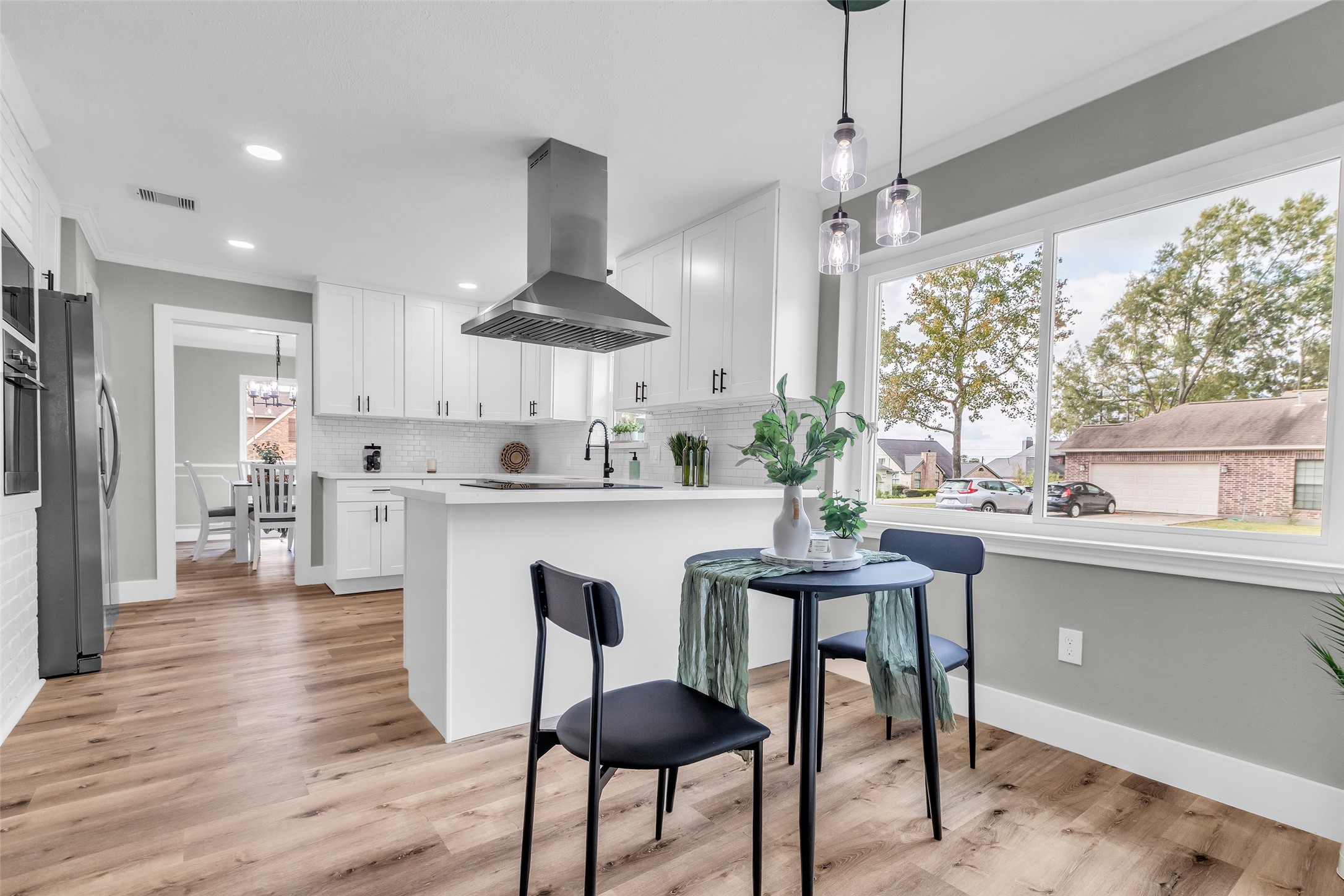 3518 Shore Shadows Drive Crosby, TX 77532 - Photo 7 of 42 a kitchen with stainless steel appliances kitchen island a table chairs in it and wooden floors