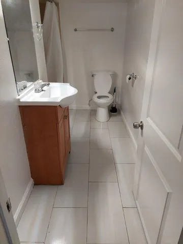 a bathroom with a sink a toilet and a mirror