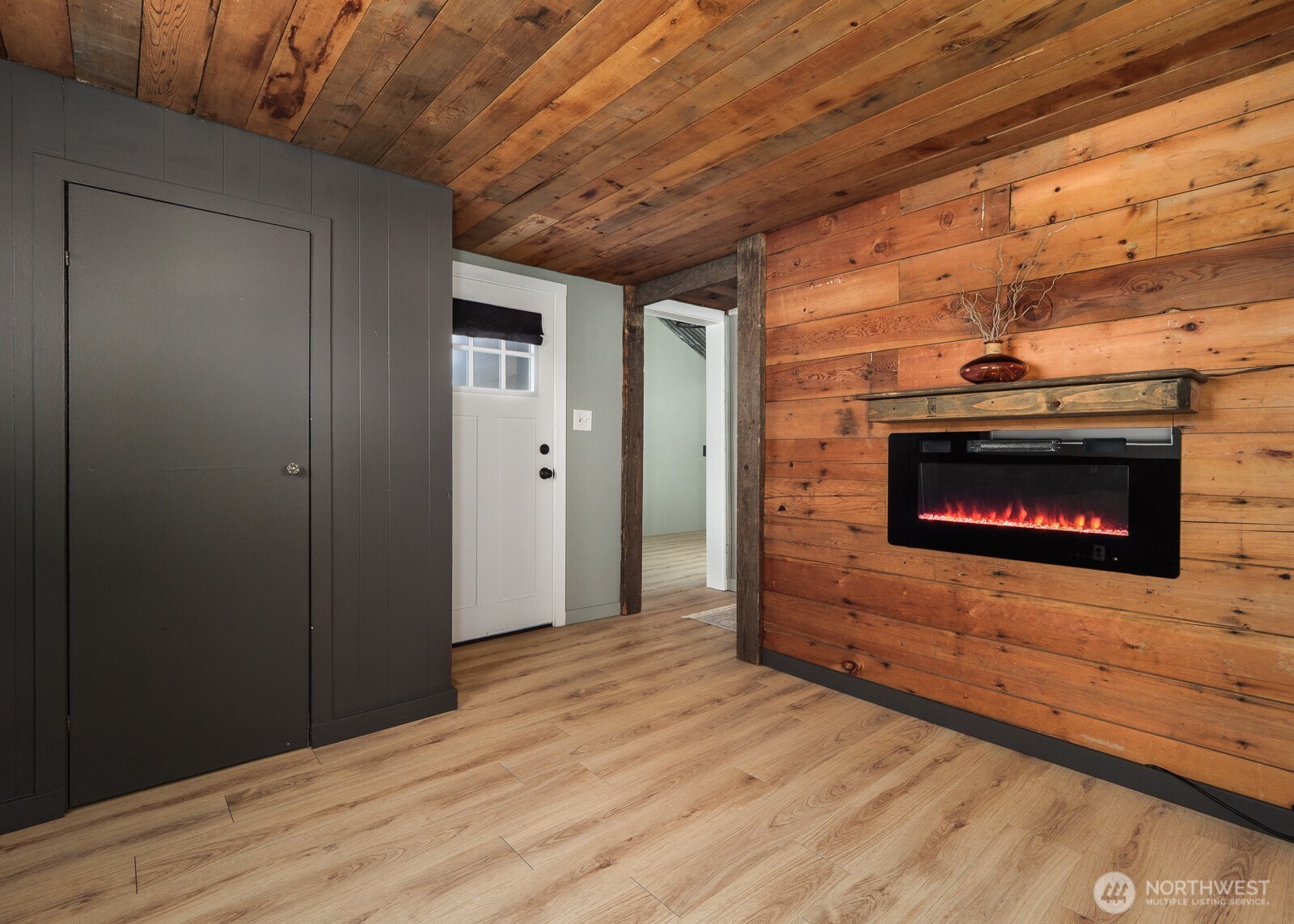233 West Washington Street Sequim, WA 98382 - Photo 23 of 40 a hallway with wooden floor a fireplace and utility room