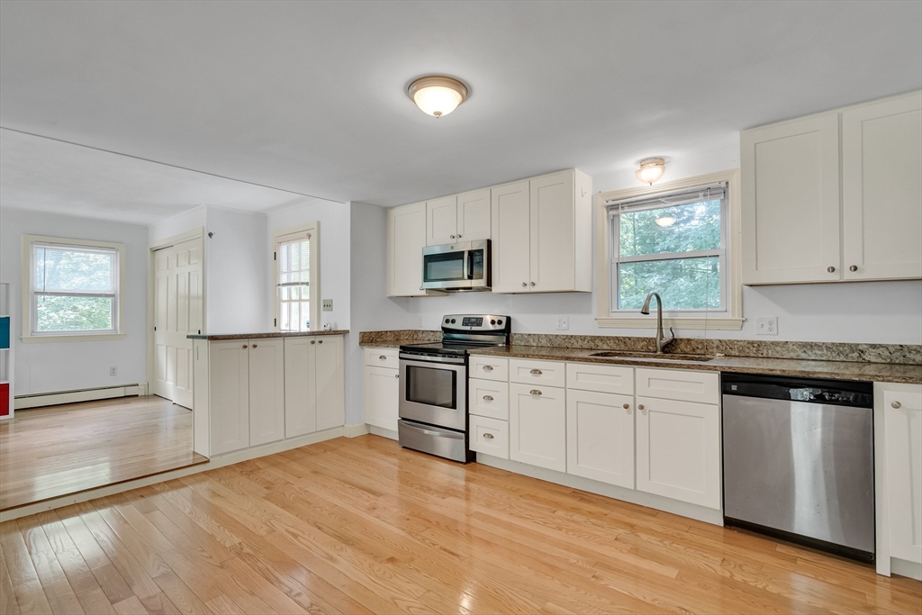 32 Dewey Road Lexington, MA 02420 - Photo 11 of 32 a kitchen with granite countertop a stove top oven sink and cabinets