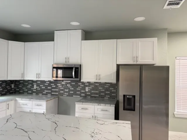 a kitchen with stainless steel appliances a refrigerator sink and microwave