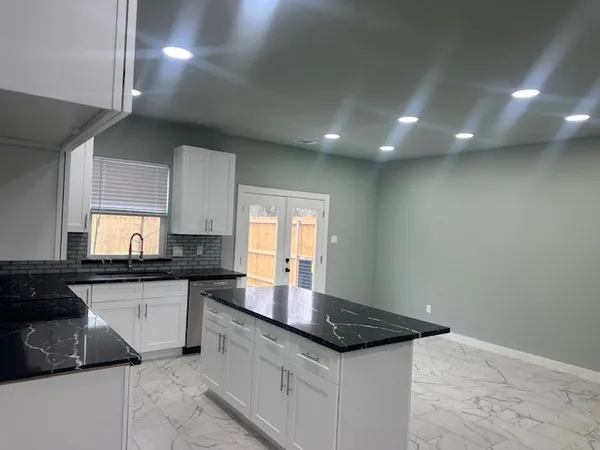 a kitchen with granite countertop a sink and cabinets