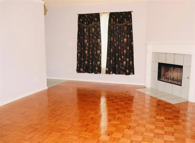 a view of an empty room with window and fireplace