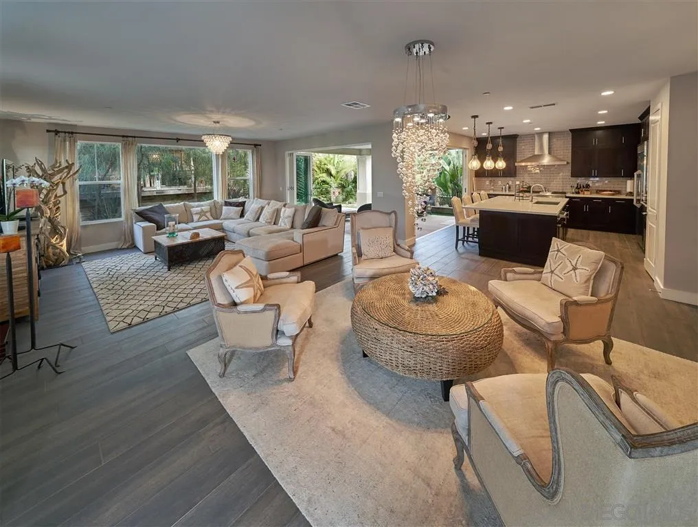 a living room with furniture and a dining table with kitchen view