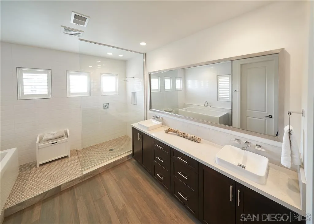 672 Polaris Drive Encinitas, CA 92024 - Photo 11 of 26 a spacious bathroom with a double vanity sink a mirror and a bathtub