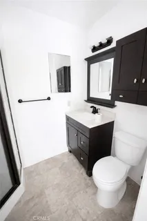 a bathroom with a sink vanity mirror and toilet