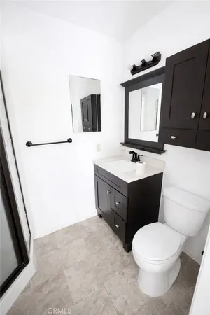 a bathroom with a sink vanity mirror and toilet