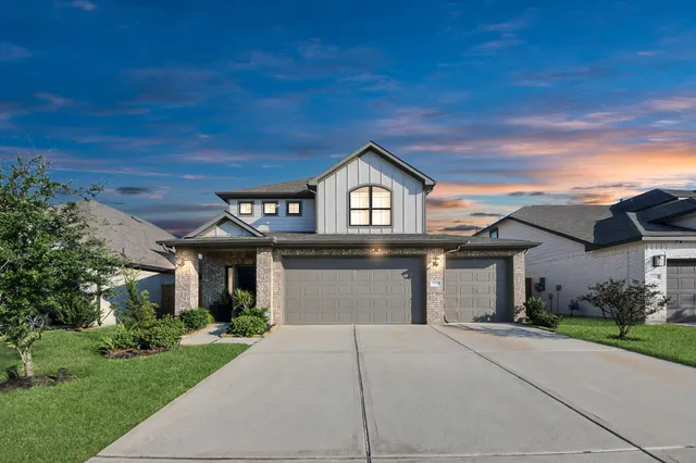 a front view of a house with a garden and trees