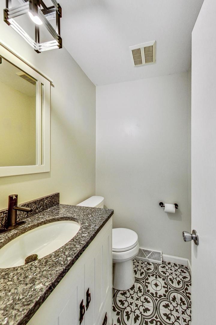 311 Deerpath Drive Winthrop Harbor, IL 60096 - Photo 18 of 48 a bathroom with a granite countertop sink a toilet and a mirror