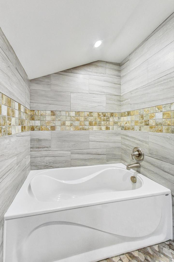 311 Deerpath Drive Winthrop Harbor, IL 60096 - Photo 23 of 48 a bathroom with a bathtub and shower