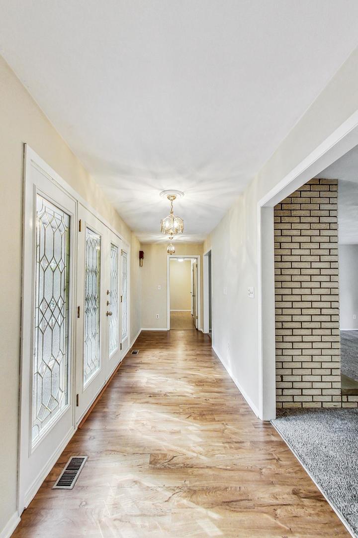 311 Deerpath Drive Winthrop Harbor, IL 60096 - Photo 5 of 48 a view of an empty room with wooden floor and windows