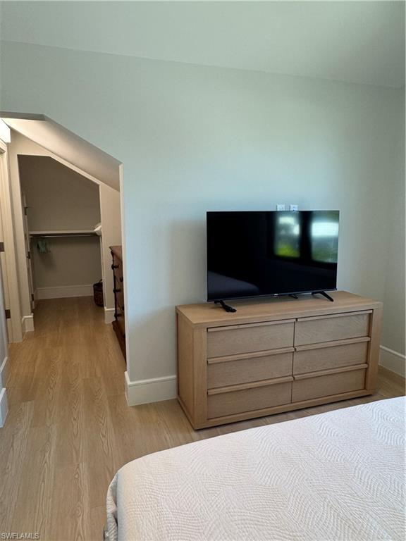 787 4th Avenue South Naples, FL 34102 - Photo 14 of 15 Bedroom with a spacious closet, light wood-type flooring, and baseboards
