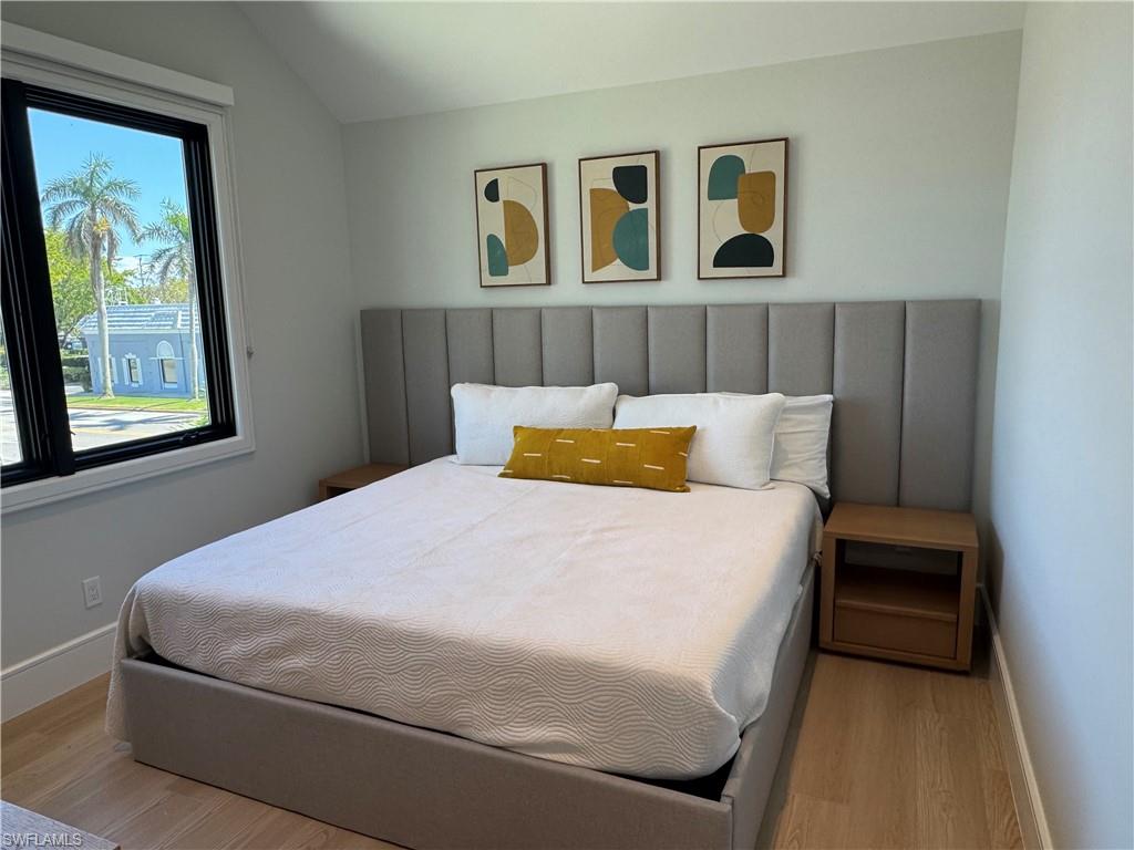 787 4th Avenue South Naples, FL 34102 - Photo 4 of 15 King Bedroom featuring baseboards, vaulted ceiling, and wood finished floors