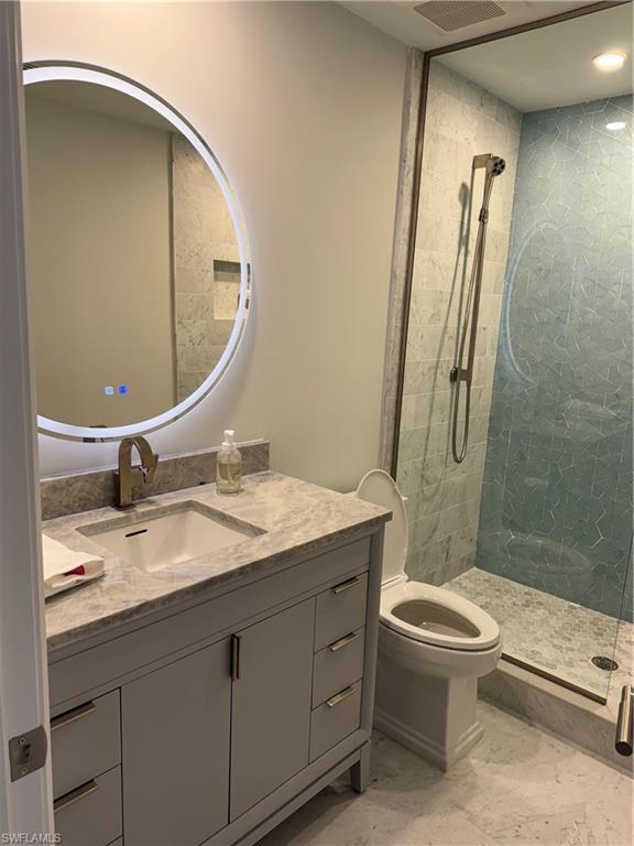 787 4th Avenue South Naples, FL 34102 - Photo 9 of 15 Bathroom featuring vanity, toilet, and tiled shower