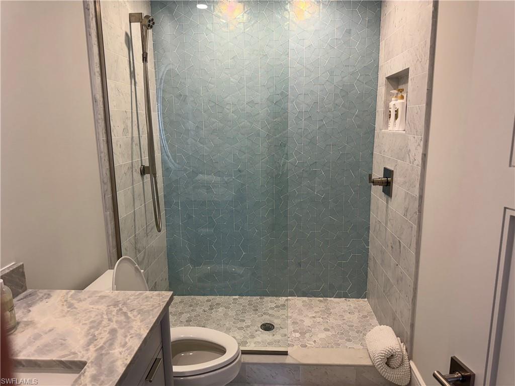 787 4th Avenue South Naples, FL 34102 - Photo 10 of 15 Bathroom featuring vanity, toilet, and tiled shower