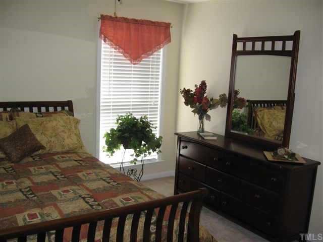 2216 Myron Drive, Unit 201 Raleigh, NC 27607 - Photo 5 of 6 a bedroom with a bed and a potted plant