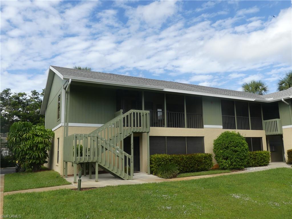 5501 Rattlesnake Hammock Road, Unit 1002 Naples, FL 34113 - Photo 1 of 9 a front view of a house with a yard and garage